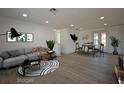 Staged living room with modern decor, wood floors, and recessed lighting at 1152 Viking Dr, Holiday, FL 34691