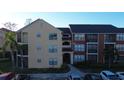 Exterior angle showing a condo building with tan and red accents; includes parking and surrounding palm trees at 11901 4Th N St # 10102, St Petersburg, FL 33716