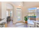 Bright foyer features a decorative glass front door, tile flooring, and views into the dining area at 12607 San Blas Loop, Largo, FL 33774