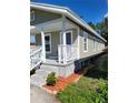 Side view of a single-story house with white trim, light siding and simple landscaping at 1321 W North B St, Tampa, FL 33606