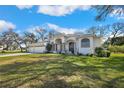 Attractive single-story home with a well-manicured lawn and mature shade trees at 13855 Rudi Loop, Spring Hill, FL 34609