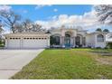 Charming single-story home featuring a three-car garage and beautiful front yard at 13855 Rudi Loop, Spring Hill, FL 34609