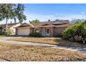 Charming single-story home with brick facade, mature landscaping, and an attached two-car garage at 14917 Barby Ave, Tampa, FL 33625