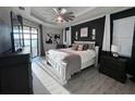 Modern main bedroom with beautiful floors, an accent wall, and balcony access at 17736 Hickok Belt Loop, Bradenton, FL 34211