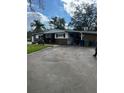 An eye-level view of the front of this one-story home and the driveway and carport at 2102 W Ivy St, Tampa, FL 33607