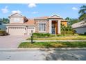 Charming two-story home with a three-car garage, stone accents, and manicured lawn on a sunny day at 21537 Draycott Way, Land O Lakes, FL 34637