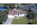 Aerial shot of a lakeside property with a well-manicured lawn, mature trees, and a private lake access at 3046 Lake Padgett Dr, Land O Lakes, FL 34639