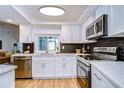 Modern kitchen with white cabinetry, stainless steel appliances, and a stylish dark backsplash at 3046 Lake Padgett Dr, Land O Lakes, FL 34639