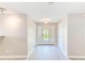 Bright entryway with a decorative front door, light hardwood floors, and neutral walls at 4606 W Oakellar Ave, Tampa, FL 33611