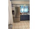 Kitchen with stainless steel refrigerator and blue cabinets at 6223 12Th S St, St Petersburg, FL 33705