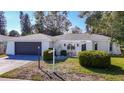 Charming single-story home with a black garage door and a gated front entrance at 714 Lemonwood Dr, Oldsmar, FL 34677