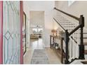 Bright foyer with tile flooring, staircase, and a view into the living room at 7645 Windchase Way, Wesley Chapel, FL 33545