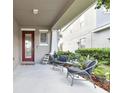 Covered front porch area with outdoor seating at 7645 Windchase Way, Wesley Chapel, FL 33545