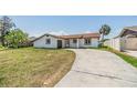 Inviting home with a concrete driveway, a well-manicured lawn, and a tidy front exterior at 8705 Tahiti Ln, Tampa, FL 33615