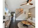 Comfortable living room showcasing dark floors, ceiling fan and beach themed accent wall at 9012 Antigua Dr, Seminole, FL 33777