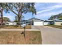 Traditional home with a green lawn, mature trees, and a mailbox at 9394 117Th Ave, Largo, FL 33773