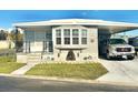 Inviting single-story home featuring a well-manicured lawn, covered parking, and appealing stone accents on the facade at 9790 66Th N St # 235, Pinellas Park, FL 33782