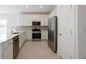 Bright kitchen with stainless steel appliances, white cabinetry, stylish backsplash, and tile flooring at 1018 Blakley St, Punta Gorda, FL 33980