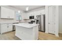 Bright kitchen with white cabinets, quartz countertops, stainless steel appliances, and wood style floors at 13729 Evergreen Valley Dr, Riverview, FL 33578