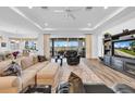 Bright living room featuring wood floors, tray ceiling, comfortable seating, and sliding doors to the lanai at 1545 Emerald Dunes Dr, Sun City Center, FL 33573