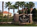 Stone sign with 'The Enclave at Richmond Place' and mature palm trees in the community at 18001 Richmond Place Dr # 222, Tampa, FL 33647