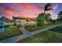 Charming one-story home with lush landscaping, sidewalk, and vibrant sunset backdrop at 2492 Laurelwood Dr # E, Clearwater, FL 33763