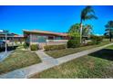 Charming one-story home with lush landscaping, sidewalk, and bright blue sky at 2492 Laurelwood Dr # E, Clearwater, FL 33763