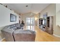 Spacious living room featuring hardwood floors, vaulted ceilings, a fan, and a gray sectional sofa at 3902 Ixora Ct, Riverview, FL 33578