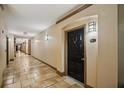 Neutral hallway with tile floors leading to apartment doors in a multi-Gathering building at 4221 W Spruce St # 1414, Tampa, FL 33607