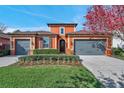 Charming two-story home features a well-manicured lawn, colorful bushes and a two-car garage at 4303 Ortona Ln, Wesley Chapel, FL 33543