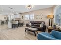 Open-concept living area with modern lighting, tile floors, and a view of the kitchen and breakfast bar at 4310 W San Luis St, Tampa, FL 33629