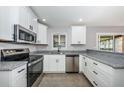 Modern kitchen featuring white cabinets, stainless steel appliances, and granite countertops, perfect for cooking at 4807 Wynwood Dr, Tampa, FL 33615