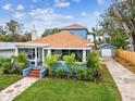 Charming bungalow with a bright blue exterior, a welcoming screened porch, and meticulous landscaping at 605 12Th N Ave, St Petersburg, FL 33701