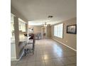 Open-concept living room featuring tile flooring, neutral walls, a ceiling fan, and shutters for plenty of natural light at 7044 Everest St, Spring Hill, FL 34606