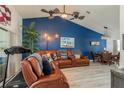 Inviting living area with a blue accent wall, wood-look floors, and a leather sofa, adjacent to the dining area at 7536 Roland Ct, New Port Richey, FL 34654