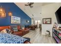 Comfortable living room with leather furniture, blue accent wall, wood-look flooring, and an adjacent dining area at 7536 Roland Ct, New Port Richey, FL 34654