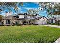 Charming two-story home with an expansive green lawn and a welcoming two-car garage, perfect for suburban living at 759 Timuquana Ln, Palm Harbor, FL 34683