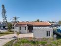 Charming single-story home featuring a red tile roof, concrete driveway, and well-maintained landscaping at 809 59Th Ave, St Pete Beach, FL 33706