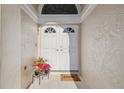 Close up on the front door featuring a double-door entry, a welcome mat, and flowers near the door at 9234 Duffer Ct, Hudson, FL 34667