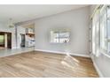 Sunlit living room with wood floors, neutral walls, and an open layout to the kitchen at 969 Britton St, Largo, FL 33770