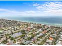 Aerial view of the desirable neighborhood offering a beautiful view of the beach, water, and blue skies at 114 12Th St, Belleair Beach, FL 33786