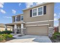 Charming two-story home with neutral colors, dark shutters, stone accents, and a two-car garage at 12326 Dora Trl, Parrish, FL 34219