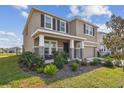 A two-story home with stone accents, a landscaped yard, a covered porch and a two-car garage at 12326 Dora Trl, Parrish, FL 34219