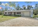 Attractive single-story home with a gravel driveway and attached garage at 14350 Hill Country Rd, Brooksville, FL 34614