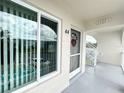 Charming condo entrance featuring a covered porch, storm door, and unit number 44 for easy access at 2434 Australia E Way # 44, Clearwater, FL 33763