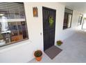 The unit's front door, with decorative security gate, is adorned with a hanging basket and potted plants at 2612 Pearce Dr # 210, Clearwater, FL 33764