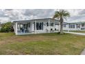 Well-maintained home featuring a covered carport, cozy front porch, and a lush green lawn at 36806 Niles Dr, Zephyrhills, FL 33542