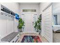 Bright entryway with tile flooring, a colorful rug, and a convenient coat rack and bench at 38205 Countryside Pl, Dade City, FL 33525