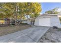 View of the house with a front lawn and a long driveway leading up to a single car garage at 4077 Ramona Dr, Spring Hill, FL 34606