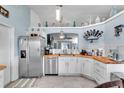 Bright kitchen featuring stainless steel appliances, white cabinets and butcher block countertops at 5106 Tanner Rd, Spring Hill, FL 34609